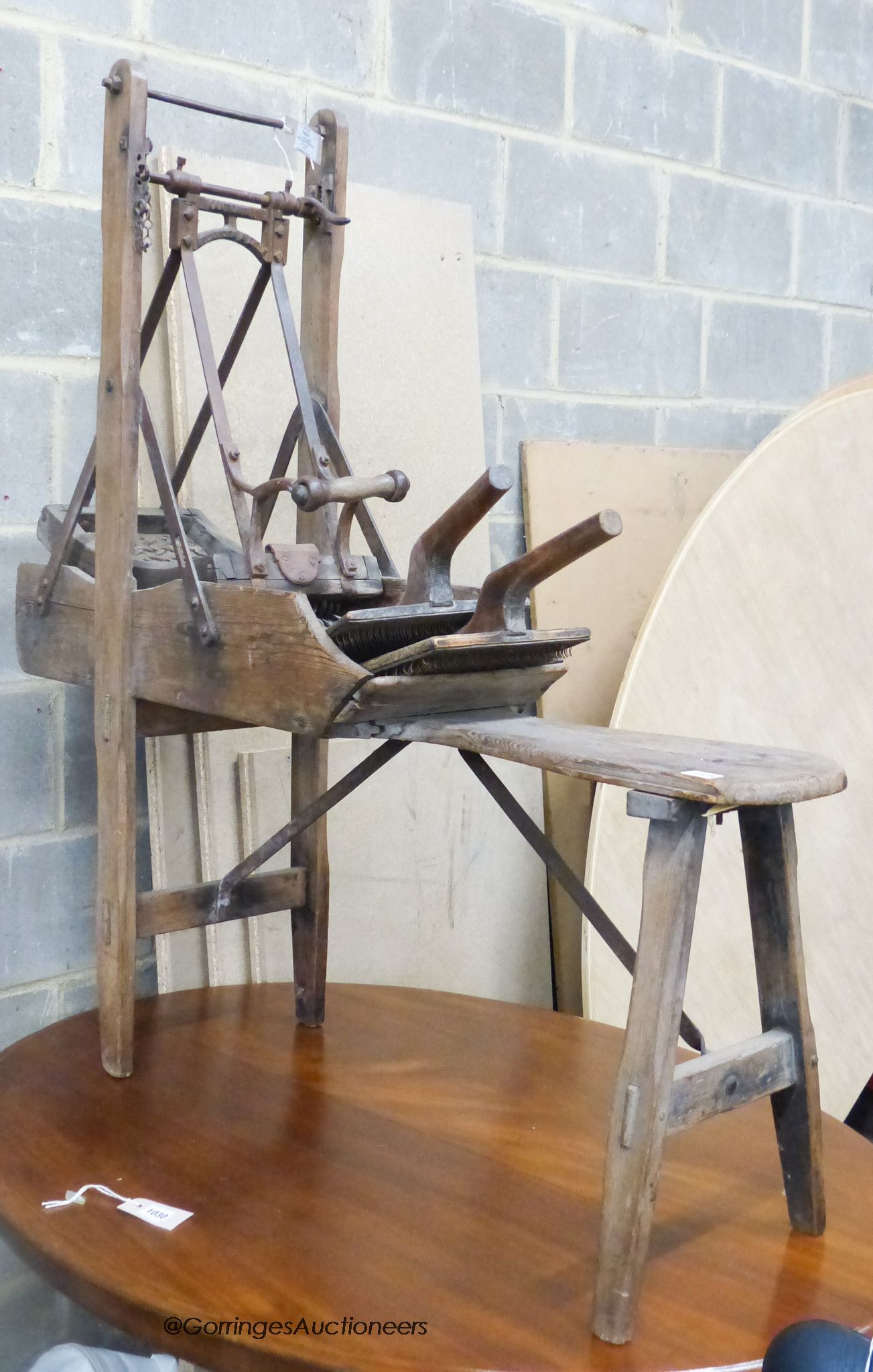 A late 19th century French Provincial (Lille) pine and wrought iron carding machine and two carding combs, length 113cm, height 120cm